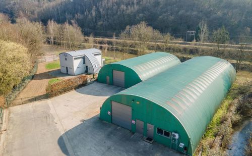 Ensemble immobilier comprenant une maison, deux entrepôts et un vaste terrain