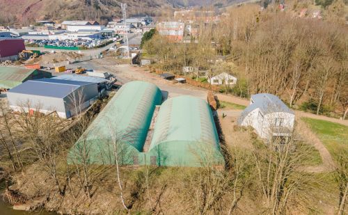 Ensemble immobilier comprenant une maison, deux entrepôts et un vaste terrain