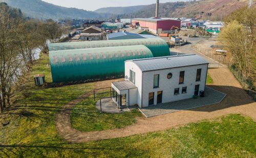 Ensemble immobilier comprenant une maison, deux entrepôts et un vaste terrain