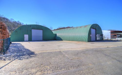 Ensemble immobilier comprenant une maison, deux entrepôts et un vaste terrain