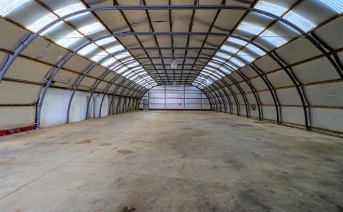 Ensemble immobilier comprenant une maison, deux entrepôts et un vaste terrain