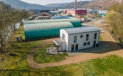 Ensemble immobilier comprenant une maison, deux entrepôts et un vaste terrain