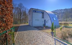 Ensemble immobilier comprenant une maison, deux entrepôts et un vaste terrain