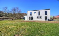 Ensemble immobilier comprenant une maison, deux entrepôts et un vaste terrain