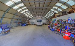 Ensemble immobilier comprenant une maison, deux entrepôts et un vaste terrain